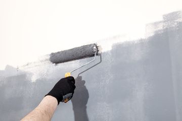 Pintor pintando una pared de gris